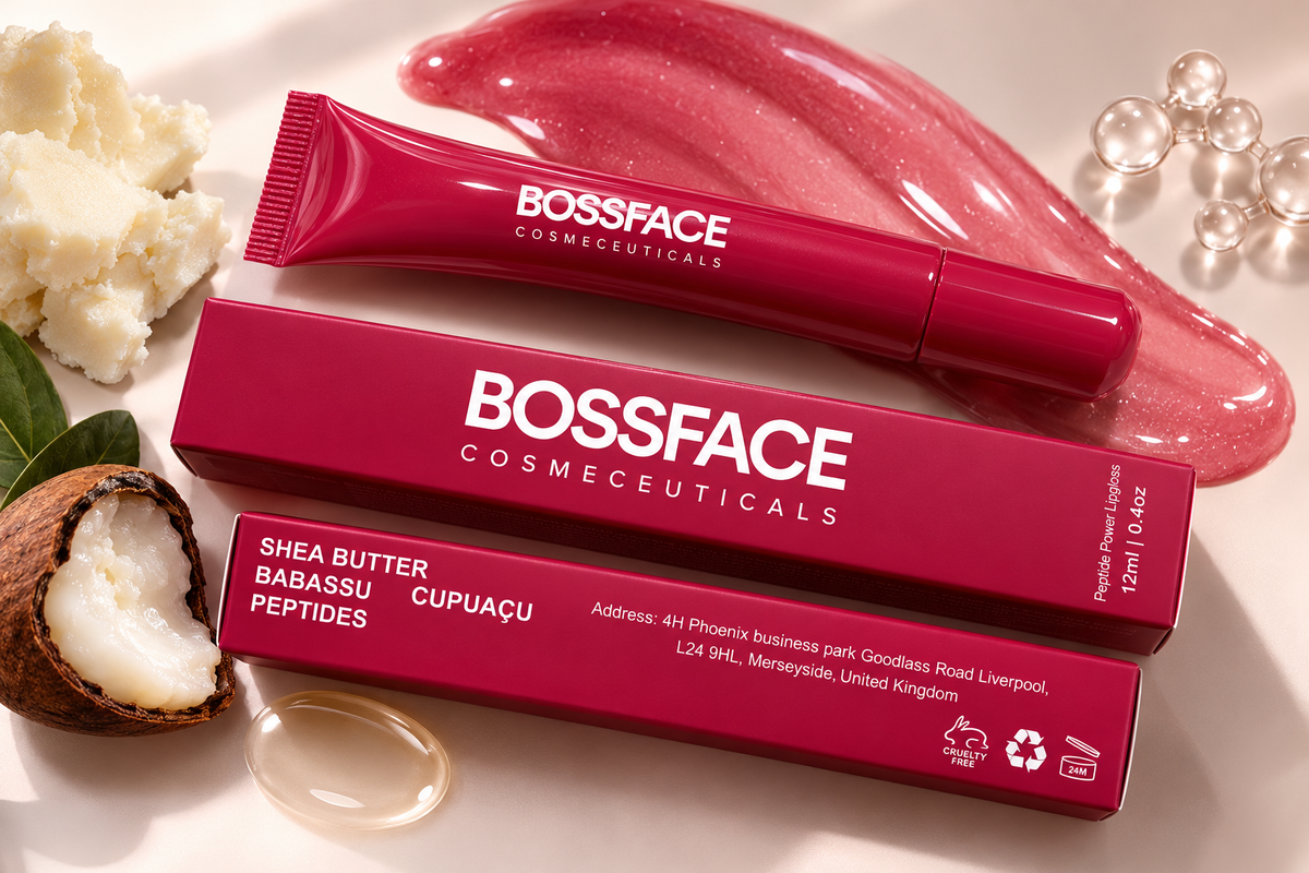 A cosmetic tube and matching box from BOSSFACE COSMECEUTICALs, labeled Shea Butter Babassu Peptides Cupuaçu, arranged on a light beige surface with coconut, cream, and glossy pink cosmetic swatches around it.