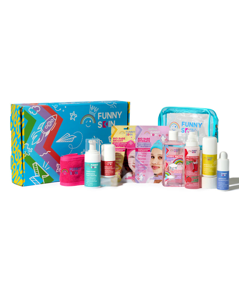 A colorful skincare gift set from Funny Skin, featuring a vibrant illustrated box, a pink jar, a teal pump bottle, pink and white sachets, a clear bottle with a blue cap, and a light blue zippered pouch, arranged on a white background.