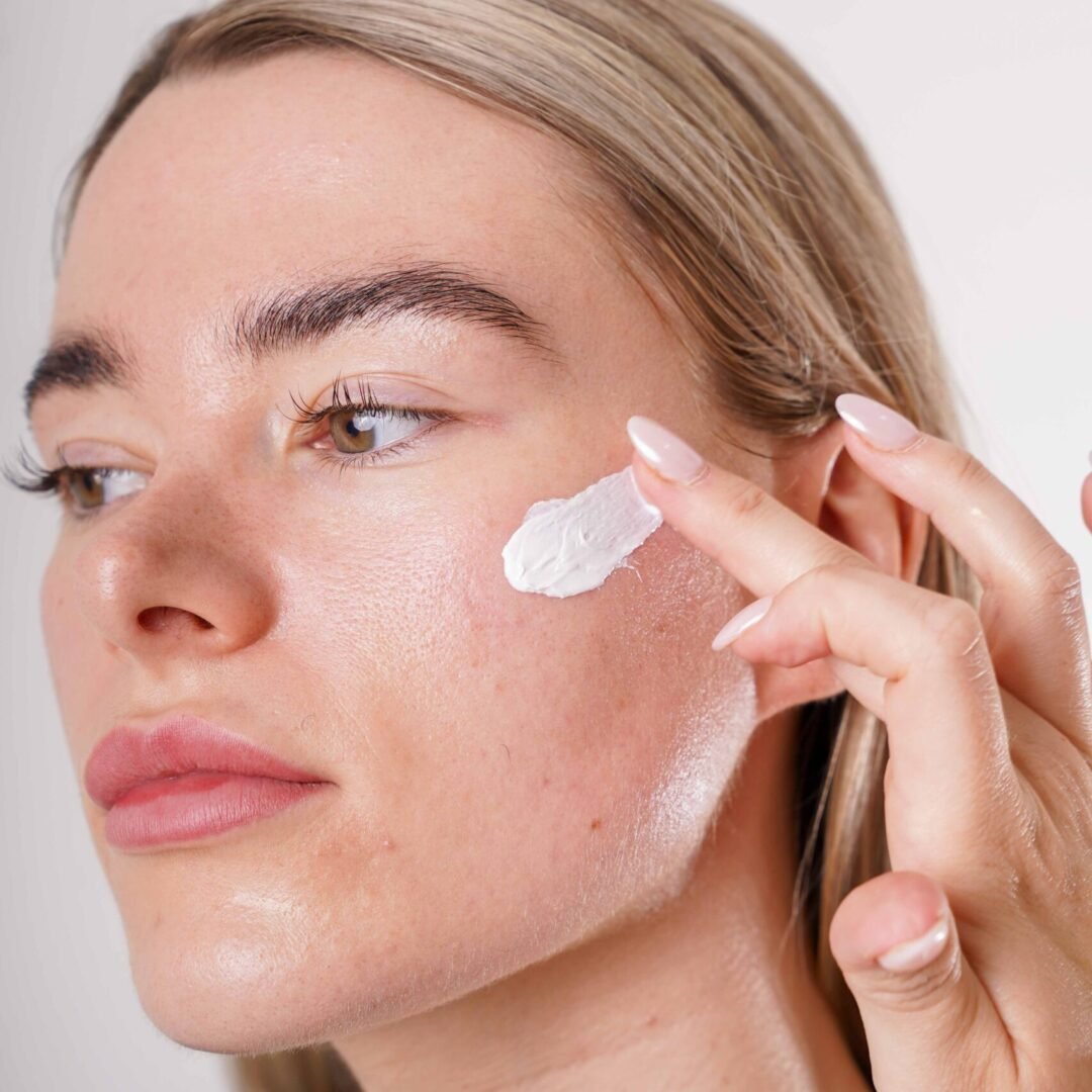 Girl with BOSSFACE cream smeared on her left cheek