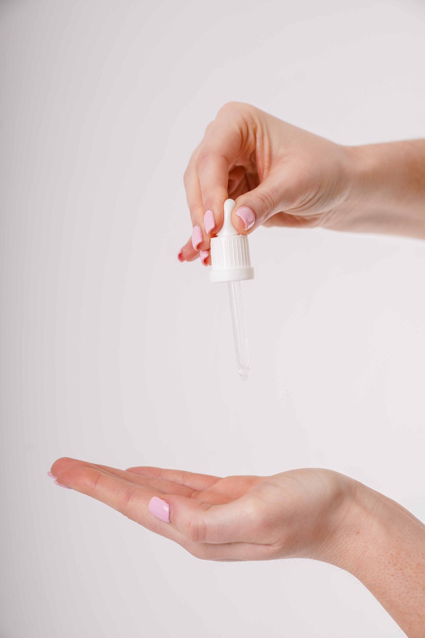 hand holding a pipet over her hand and drops of BFx VTC20 on her hand