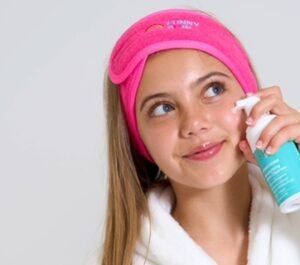 A tween girl using Funny Foam Cleanser by funny skin with the product on her cheek